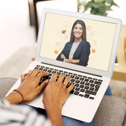 Les mains d’une femme tapant sur le clavier d’un ordinateur portable dont l’écran présente le contenu de la section QI Lussier.